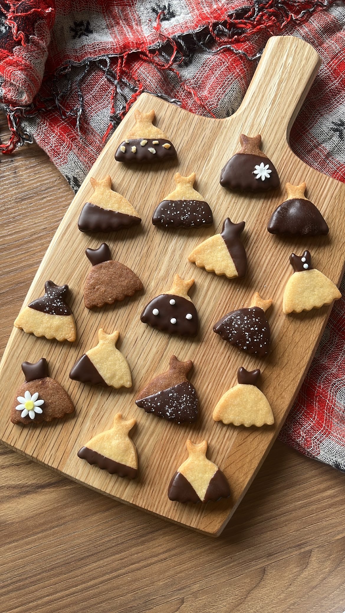 Dress-shaped cookies dipped in chocolate, decorated in different patterns.